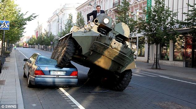 Mayor crushing cars with a tank